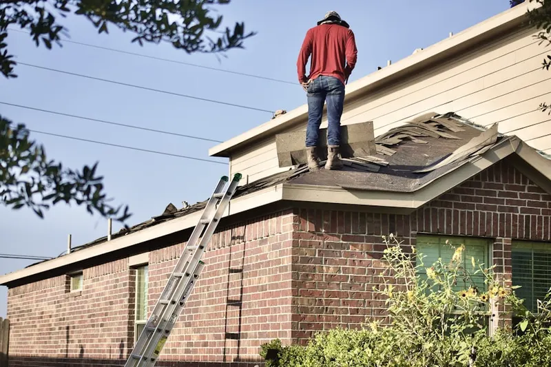 Professional roofer working on a residential roof in Henrys